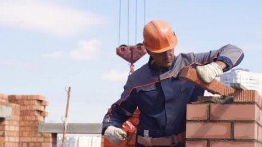 Minsk, Beyaz Rusya, 14 Ağustos 2018 - İşçi bir şantiyeye tuğla döşer. Tuğla sanayi. İnşaatçılar tuğlabir apartman inşa ediyoruz.