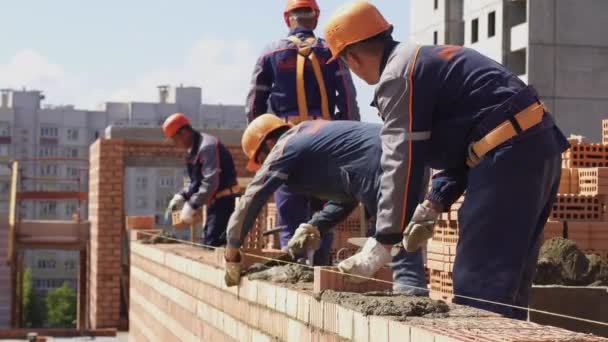 Mińsk, Białoruś, sierpień 14 2018-budowniczowie budują cegły. Pracownik kładzie cegły na placu budowy. Cegły przemysłowe — Wideo stockowe