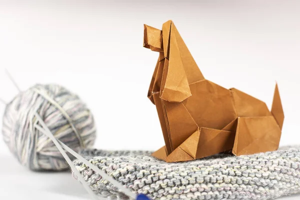 Concepto de origami artesanal de una casa acogedora - un perro con bolas de lana se sienta en una pestaña. Papel de arte hecho a mano de cerca plano de estudio . — Foto de Stock