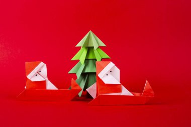 Yeni yıl kartı el yapımı origami Noel Baba ağaçları ile bir kızak üzerinde. Noel konsepti kış kırmızı backgroun çekilen süslemeleri stüdyo hazırlanmış