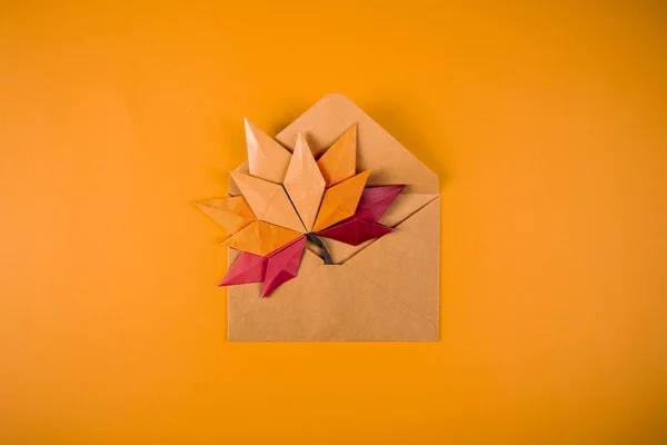 Origami papel otoño concepto caído hojas carta en un sobre sobre sobre un fondo naranja arte artesanal — Foto de Stock