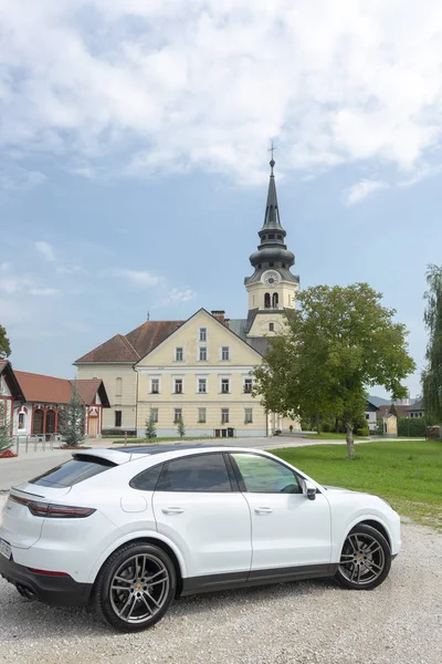 Eslovenia Liubliana, 31 de agosto de 2019 - White Porsche Cayenne Coupe Turbo S desde Stuttgart durante la prueba de manejo frente a la antigua iglesia — Foto de Stock