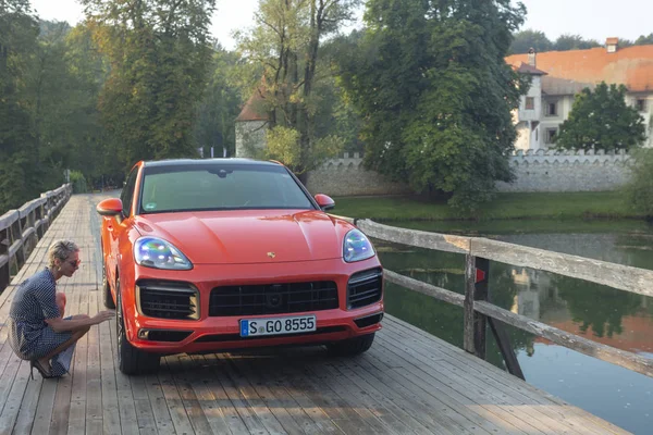 Eslovenia Liubliana, 31 de agosto de 2019 - La mujer intenta cambiar una rueda del Porsche Cayenne Coupe Turbo S de Stuttgart durante la prueba de manejo — Foto de Stock