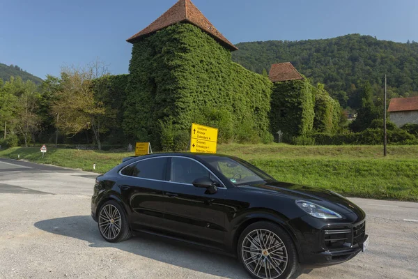 Eslovênia ljubljana, 31 de agosto de 2019 - Porsche Cayenne Coupe Turbo S de Stuttgart durante test drive perto do antigo castelo medieval com paredes em folhas — Fotografia de Stock