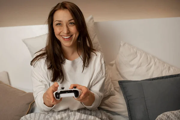 Caucasien attrayant femme joue à des jeux sur console en utilisant joystick et sourire — Photo