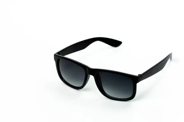 Siyah plastik çerçeveli Unisex güneş gözlükleri ve beyaz arka planda koyu renkli lensler. — Stok fotoğraf