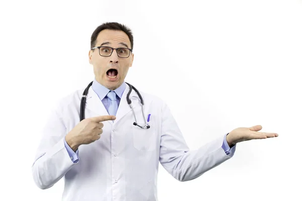 Chockad förvånad läkare i medicinsk uniform pekar med fingret för att öppna handflatan — Stockfoto
