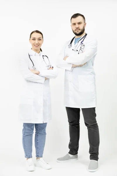 Zwei junge Ärzte in weißem Arztkittel mit verschränkten Armen — Stockfoto