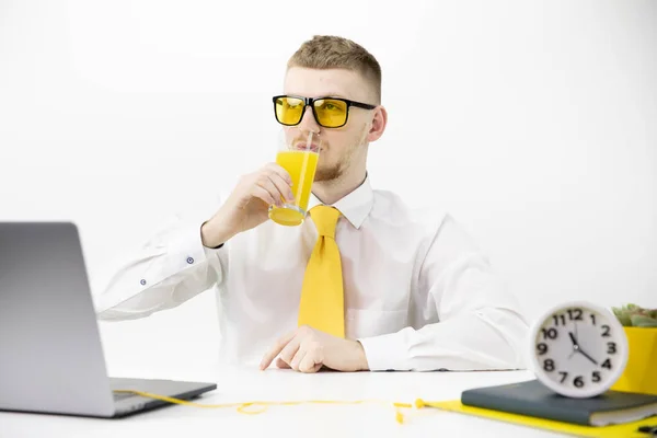 Hombre guapo oficinista bebe jugo de naranja recién exprimido. Aislado — Foto de Stock