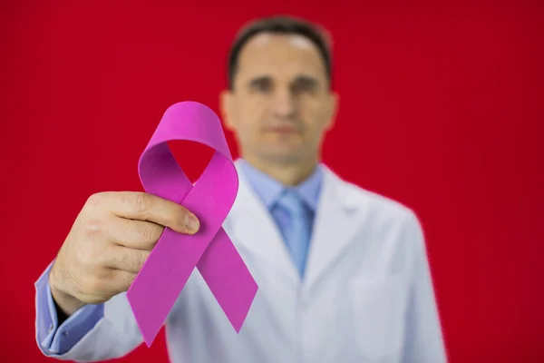 Close up pink ribbon in doctors hand, Breast thyroid cancer awareness campaigns
