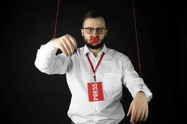 Depressiv journalist håller händer bundna med rep som marionett inslagning mun — Stockfoto