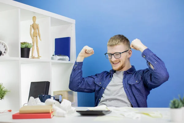 Caucásico feliz hombre en casual camisa en oficina mantiene las manos levantadas . — Foto de Stock