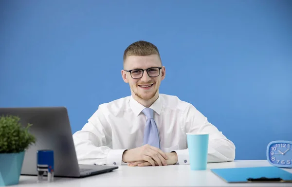 Consultor de crédito masculino vestido con camisa blanca con corbata azul sonríe positivamente — Foto de Stock