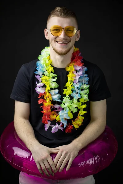 Young caucasian handsome man in sunglasses, black t-shirt with lei on his neck — Stock Photo, Image