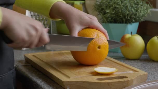 Fette casalinga arancio con coltello su tavola di legno. Mani in primo piano. — Video Stock