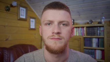 Kızıl saçlı adam canlı video konferansında bilgisayarla sohbet ediyor.