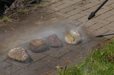 Yüksek basınçlı çamaşır makinesi taşları temizler.