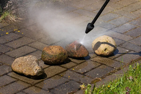 Lavadora de alta presión limpia las piedras de cerca en la línea de jardín de la casa de campo — Foto de Stock