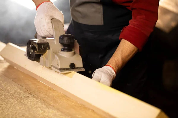 Pialla elettrica smussa fuori pezzo di legno sul banco da lavoro — Foto Stock