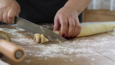 Kadın fırıncı çörek dilimleri için tarçınlı rulo yapar.