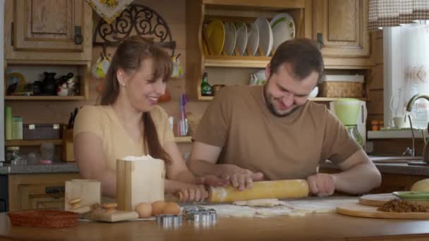 Couple aimant assis à la table et rouler ensemble la pâte sans levure. — Video