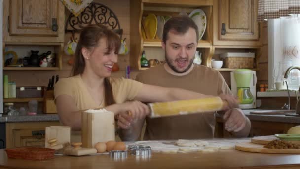 Le mari roule une pâte sans levure pour faire des biscuits. — Video