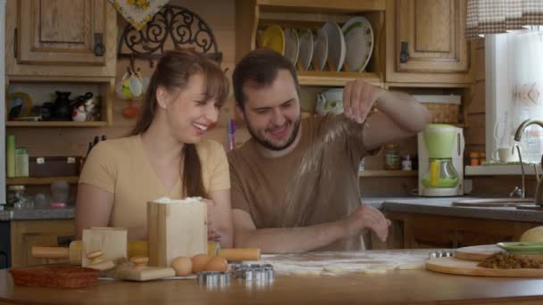 Couple aimant assis à la table saupoudrer de farine et rouler la pâte sans levure — Video