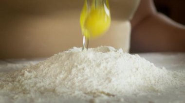 Un tozu ile kaplanmış un üzerinde çiğ yumurta kırma, pişirme