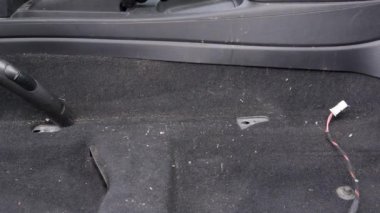 Arabada elektrikli süpürge kullanan bir erkek işçi. Düzenli temizlik otomatiği
