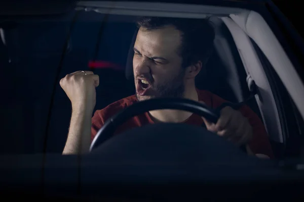 Fahrer sitzt nachts am Auto und gestikuliert zufrieden mit glücklicher Fratze — Stockfoto