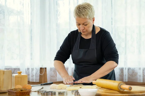 Mujer de mediana edad haciendo galletas caseras y masa amasando pastelería —  Fotos de Stock