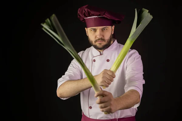 Chef-kok in uniform heeft twee preistengels die ze kruisen als een wapen. — Stockfoto