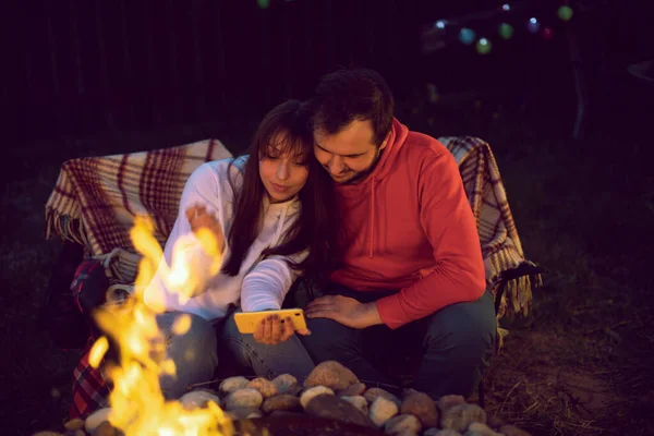 Couple of lovers making selfies in glow of fire at romantic party by bonfire — Stock Photo, Image