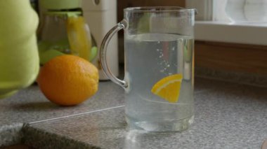 Genç beyaz kız mutfakta limonata hazırlıyor..