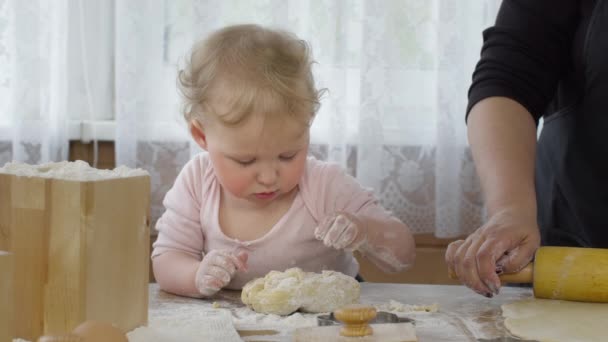 Mignon bébé petite-fille mélange la pâte pour la pâtisserie avec dans la cuisine et sourire drôle — Video