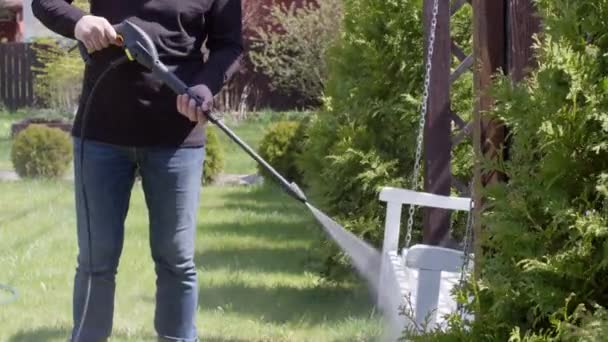 Man disinfecting with reagent bench hanging on chains with high pressure washer — Stock Video