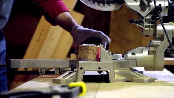 Menuisier mâle coupe l'extrémité de la poutre en bois à l'aide d'une scie circulaire avec laser — Video