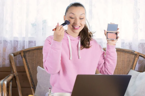 Stylish woman testing new cosmetic products recording process on video camera