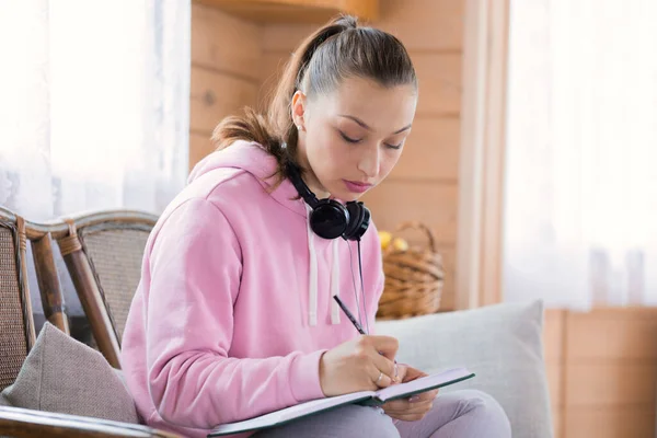 Hermosa mujer milenaria estudio en casa, dibuja boceto, escribir notas a hacer lista — Foto de Stock