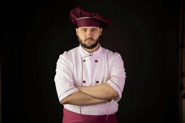 Retrato de cocinero barbudo serio en uniforme cruzado de manos mirando a la cámara —  Fotos de Stock