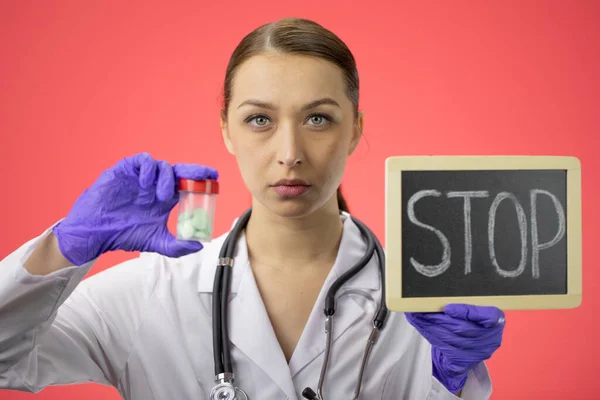 Fiatal vonzó női orvos tartja adag tablettát és ellátás szöveges stop — Stock Fotó