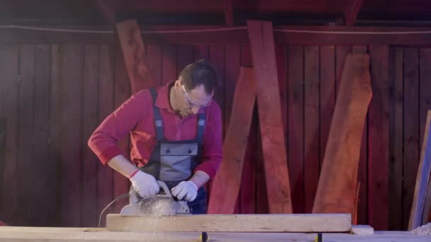 작업대 위에서 일하는 사람의 목수는 전기 플래너 로 나무 들보 표면을 청소 한다 — 비디오