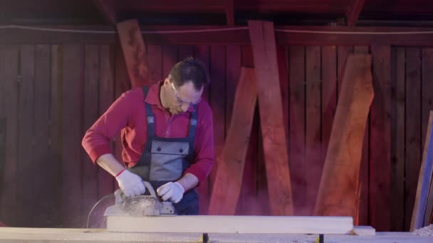 カーペンターは、電気プランナーとハエのおがくずで木製のビームの表面をきれいにする — ストック動画