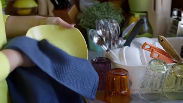 마른 와플 타월을 사용하여 깨끗하게 씻은 접시를 닦는 여자 — 비디오