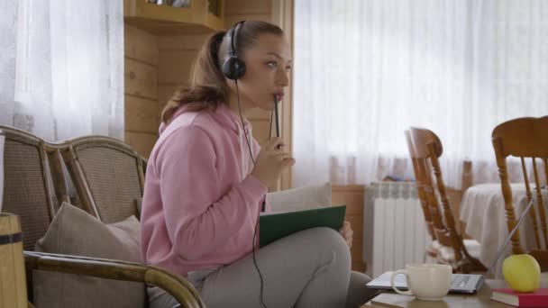 Caucásico chica en auriculares tomando curso en línea en Internet en auto-aislamiento — Vídeo de stock