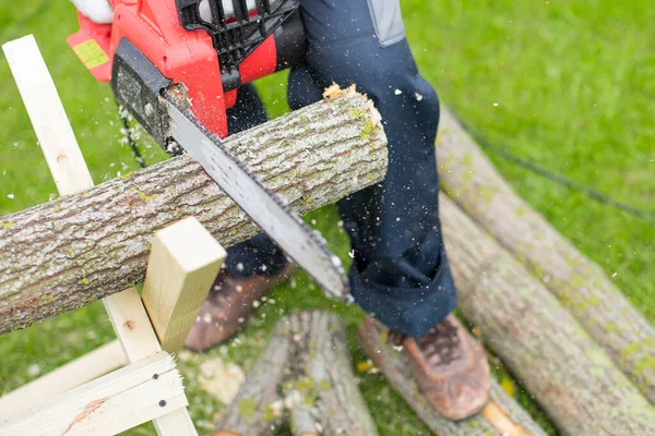 Close up of woodcutter sawing, electric saw in motion, sawdust fly to sides
