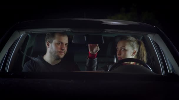 차 안에 앉아 있는 아름다운 한 부부, 남자가 여자에게 운전하는 법을 가르친다 — 비디오