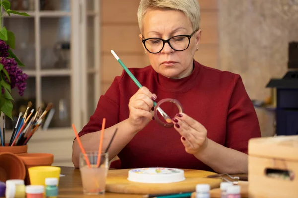 Mujer creativa pinta en maceta de cerámica de arcilla en el espacio de trabajo del estudio de arte en casa, DIY — Foto de Stock