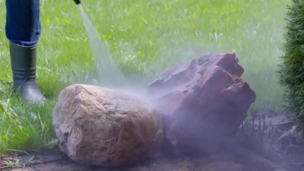 Jardinero lava piedras decorativas de la suciedad y el musgo usando lavadora de alta presión — Vídeos de Stock