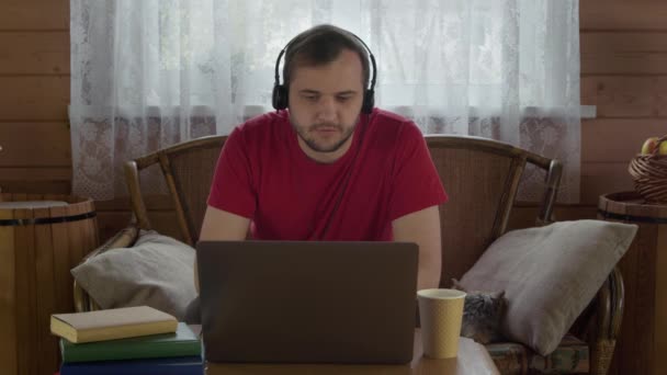 Junger gutaussehender Mann arbeitet zu Hause per Webcam am Laptop